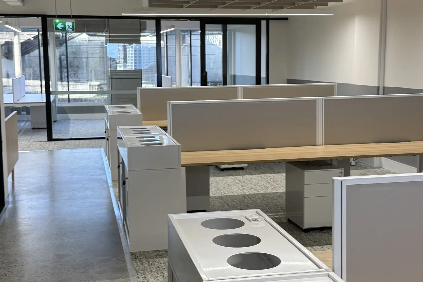 Cleaned office workstations and a breakout area after hours, desks clear and lights low